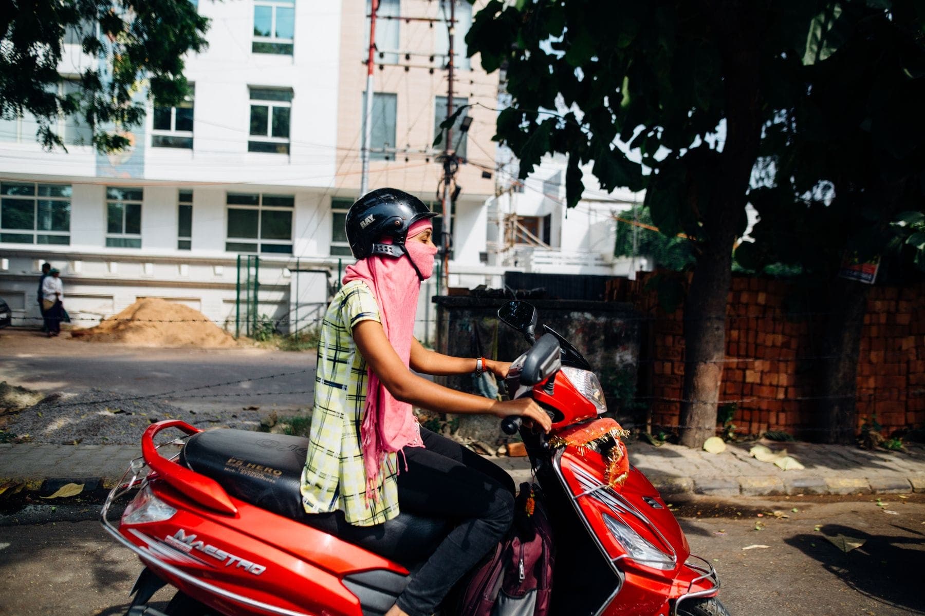 A woman riding a scooter on a city street